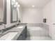 Bright bathroom with double sink vanity with granite countertop and a tiled soaking tub at 4575 Dean Martin Dr # 1103, Las Vegas, NV 89103