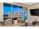 Living room with floor-to-ceiling windows showcasing a beautiful city view and a mounted flat screen television at 4575 Dean Martin Dr # 1103, Las Vegas, NV 89103