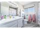 Updated bathroom featuring white tiled countertops, vanity with storage, window, and updated fixtures at 4708 Royal Sunset Ct, Las Vegas, NV 89130