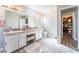 Bright bathroom featuring a double sink vanity, granite countertop, tile floors, and a walk-in closet at 4708 Royal Sunset Ct, Las Vegas, NV 89130