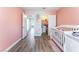 Bedroom featuring pink walls, wood floors, white crib, and closet at 4708 Royal Sunset Ct, Las Vegas, NV 89130