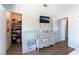 Bright bedroom with wood floors, dresser with TV, walk-in closet, and colorful toys at 4708 Royal Sunset Ct, Las Vegas, NV 89130