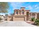Charming two-story home boasts a three-car garage and a well-manicured front yard, with a tile roof and neutral colored stucco at 4708 Royal Sunset Ct, Las Vegas, NV 89130
