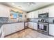 Bright kitchen features white cabinets, marble countertops, stainless steel appliances, and tile flooring at 4708 Royal Sunset Ct, Las Vegas, NV 89130