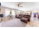 Spacious living room with comfortable seating, large windows, tile flooring, and access to the backyard at 4708 Royal Sunset Ct, Las Vegas, NV 89130