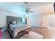 Main bedroom featuring tufted headboard, ceiling fan, wood floors, and attached walk-in closet at 4708 Royal Sunset Ct, Las Vegas, NV 89130