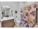 Modern bathroom featuring a wood vanity, toilet, and a shower with a patterned curtain at 5095 E Long Leaf Ct, Pahrump, NV 89061