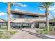Contemporary clubhouse entrance with palm trees, glass doors, and desert landscaping at 5095 E Long Leaf Ct, Pahrump, NV 89061