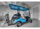 Garage featuring custom flooring, storage, and a blue Icon golf cart at 5095 E Long Leaf Ct, Pahrump, NV 89061