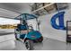 Garage featuring custom flooring, storage, and a blue Icon golf cart at 5095 E Long Leaf Ct, Pahrump, NV 89061