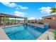 Backyard pool with a covered dining and grilling area, a water feature, and desert landscaping at 5095 E Long Leaf Ct, Pahrump, NV 89061