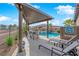 Resort-style pool with covered patio, lounge chairs, and lush tropical landscaping at 5095 E Long Leaf Ct, Pahrump, NV 89061
