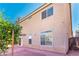 An exterior side view of the house shows a brick backyard, windows, stucco and a bearing fruit tree at 5350 Tulip Hill Ave, Las Vegas, NV 89141