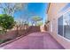Wide backyard view of the house shows brick flooring, a block fence, windows and trees overhead at 5350 Tulip Hill Ave, Las Vegas, NV 89141