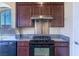 Kitchen featuring stainless steel appliances, granite countertops, and dark wood cabinets at 5350 Tulip Hill Ave, Las Vegas, NV 89141