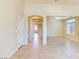 Open-concept living area featuring neutral-toned walls, arched doorway, tile flooring, and natural light at 5350 Tulip Hill Ave, Las Vegas, NV 89141