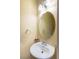 Powder room featuring a pedestal sink, oval mirror, and modern lighting at 5350 Tulip Hill Ave, Las Vegas, NV 89141