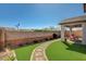 Serene backyard featuring well-maintained artificial turf, a covered patio, and brick accents at 7018 Hunts Corner St, Las Vegas, NV 89166
