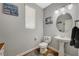 Powder room featuring pedestal sink, round mirror, and decorative wall art creating a clean space at 7018 Hunts Corner St, Las Vegas, NV 89166