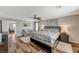 Bright main bedroom featuring a comfortable lounge area, ceiling fan, and wood-style floors at 7018 Hunts Corner St, Las Vegas, NV 89166
