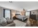 Bright main bedroom featuring a comfortable lounge area, ceiling fan, and wood-style floors at 7018 Hunts Corner St, Las Vegas, NV 89166
