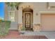 Charming front entrance with stone accents, decorative door, and well-manicured landscaping at 7018 Hunts Corner St, Las Vegas, NV 89166