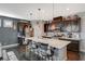 Modern kitchen featuring an island with seating, stylish lighting, and stainless steel appliances at 7018 Hunts Corner St, Las Vegas, NV 89166