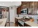 Contemporary kitchen features dark wood cabinets, stainless steel appliances, and tile backsplash at 7018 Hunts Corner St, Las Vegas, NV 89166
