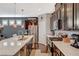 Modern kitchen with dark wood cabinetry, stainless steel appliances, and a bright white countertop at 7018 Hunts Corner St, Las Vegas, NV 89166