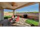 Charming covered patio with a dining set and views of the landscaped backyard for outdoor gatherings at 7018 Hunts Corner St, Las Vegas, NV 89166