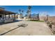 Large concrete patio with a basketball hoop, trampoline, outdoor kitchen, and comfortable seating area at 720 Camino La Paz, Henderson, NV 89012
