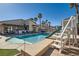Inviting backyard with a pool, slide, and outdoor kitchen, perfect for enjoying warm days and entertaining guests at 720 Camino La Paz, Henderson, NV 89012