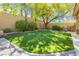 The backyard showcases well-manicured artificial turf, mature trees, and privacy landscaping at 7427 Tomahawk Bend Ave, Las Vegas, NV 89113