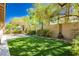 The backyard offers mature trees, lush landscaping, a fire pit, and ample space for entertaining at 7427 Tomahawk Bend Ave, Las Vegas, NV 89113