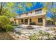 Outdoor living space with covered patio, built-in grill, fire pit, and lush landscaping at 7427 Tomahawk Bend Ave, Las Vegas, NV 89113