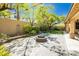 Backyard featuring pavers, lush landscaping, a stone fire pit, and string lights for outdoor ambiance at 7427 Tomahawk Bend Ave, Las Vegas, NV 89113