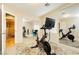 Bright bedroom with a Peloton exercise bike, mirrored closet doors, and neutral color scheme at 7427 Tomahawk Bend Ave, Las Vegas, NV 89113