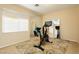 Bright exercise room with a stationary bike, mirrors, and large window for natural light at 7427 Tomahawk Bend Ave, Las Vegas, NV 89113