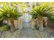 The front entrance features custom stone pillars with palm trees and a beautiful wrought iron gate at 7427 Tomahawk Bend Ave, Las Vegas, NV 89113