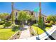 A lush green lawn with desert landscaping surrounds the house, complemented by palm trees and manicured bushes at 7427 Tomahawk Bend Ave, Las Vegas, NV 89113