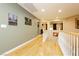 Upstairs hallway with hardwood floors, neutral wall paint, and view of the living room at 7427 Tomahawk Bend Ave, Las Vegas, NV 89113