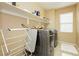 Functional laundry room equipped with modern gray washer and dryer and convenient overhead shelving at 7427 Tomahawk Bend Ave, Las Vegas, NV 89113