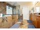 Luxurious main bathroom featuring stone tile, glass shower and wood cabinets at 7427 Tomahawk Bend Ave, Las Vegas, NV 89113