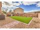 Backyard featuring synthetic grass, brick trim, gravel landscaping, and a fence for privacy at 7948 Eastern Elk St, Las Vegas, NV 89149