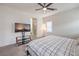 Bedroom with a ceiling fan, mounted television, and bathroom access at 7948 Eastern Elk St, Las Vegas, NV 89149
