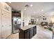 Open concept kitchen with an island featuring granite countertop, stainless steel fridge and tile floors at 7948 Eastern Elk St, Las Vegas, NV 89149