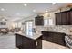 Gourmet kitchen with dark cabinets, an island, granite countertops, and stainless steel appliances at 7948 Eastern Elk St, Las Vegas, NV 89149