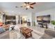 Spacious living room with tile flooring, a ceiling fan, and dark wood kitchen cabinets at 7948 Eastern Elk St, Las Vegas, NV 89149