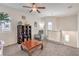 Cozy loft area featuring a ceiling fan, wood coffee table, comfortable chair, and open staircase with white banister at 7948 Eastern Elk St, Las Vegas, NV 89149