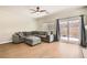 Living room with a gray sectional sofa, wood floors, and a sliding door leading to the backyard at 813 Royal Elm Ln, Las Vegas, NV 89144